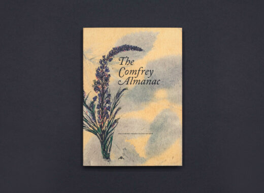 A colour photograph of The Comfrey Almanac publication on a black background